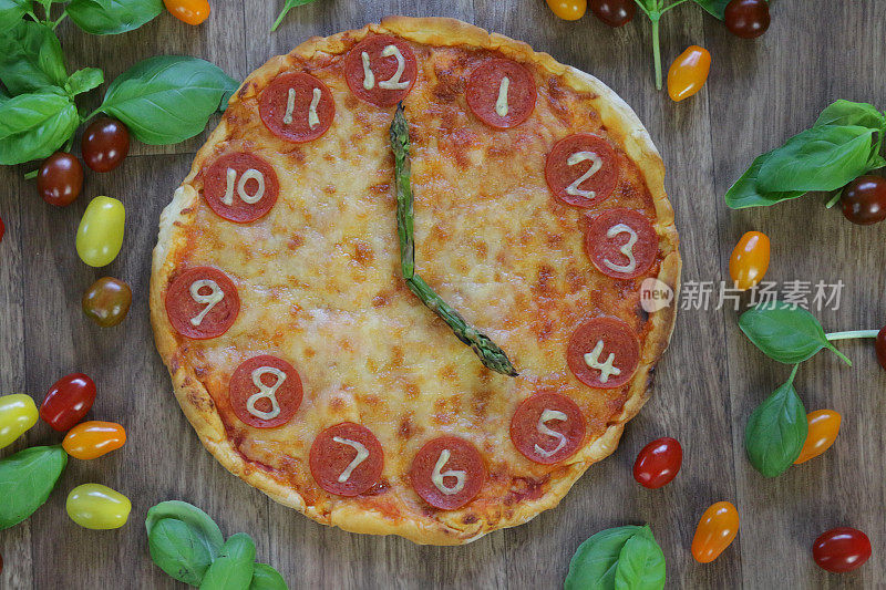 这是一个自制披萨时钟的图像，上面有意大利辣香肠切片、马苏里拉奶酪和芦笋作为时钟指针，显示时间是17:00 - 5:00，这是意大利披萨餐厅为孩子们的生日派对提供的儿童披萨时钟